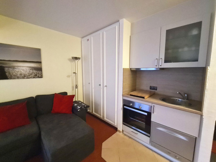 Zwei Personen Ferienwohnung 208 in der Strandburg auf Juist - gemütliches Sofa mit voll ausgestatteter Küche.